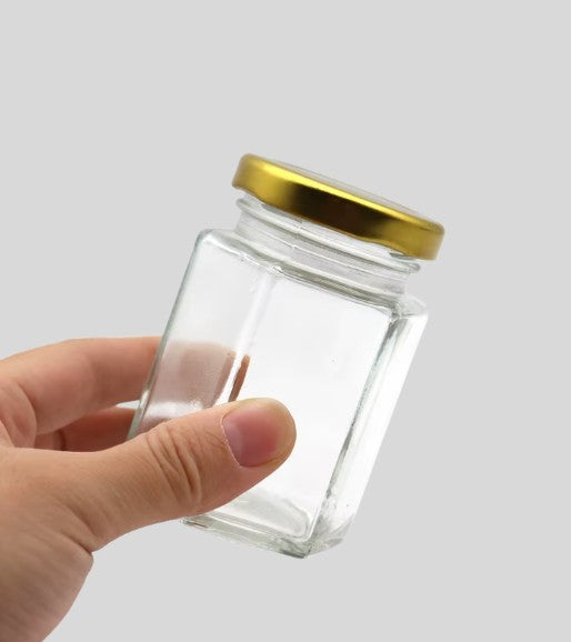 Frasco de vidrio hexagonal con tapa dorado