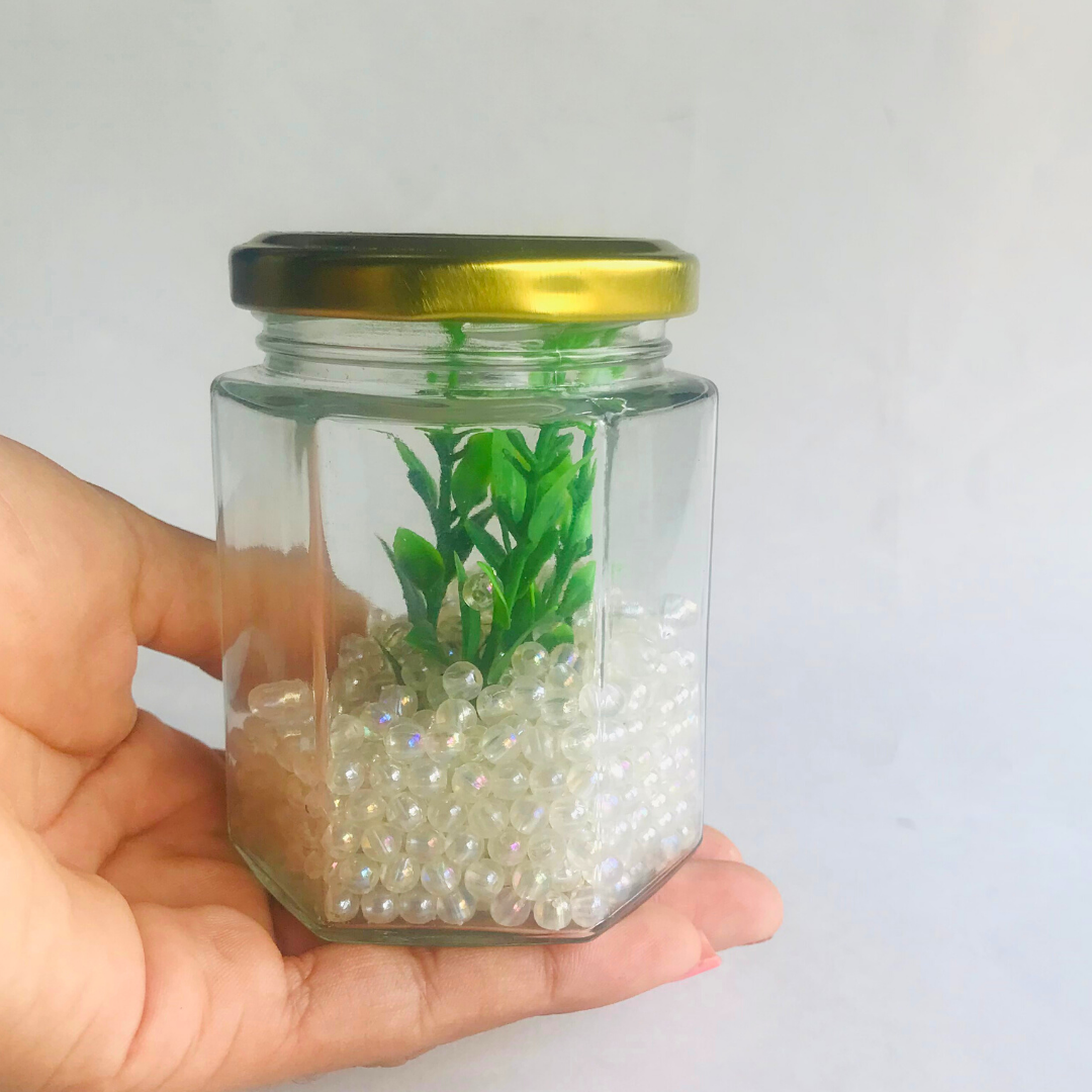 Frasco de vidrio hexagonal con tapa dorado