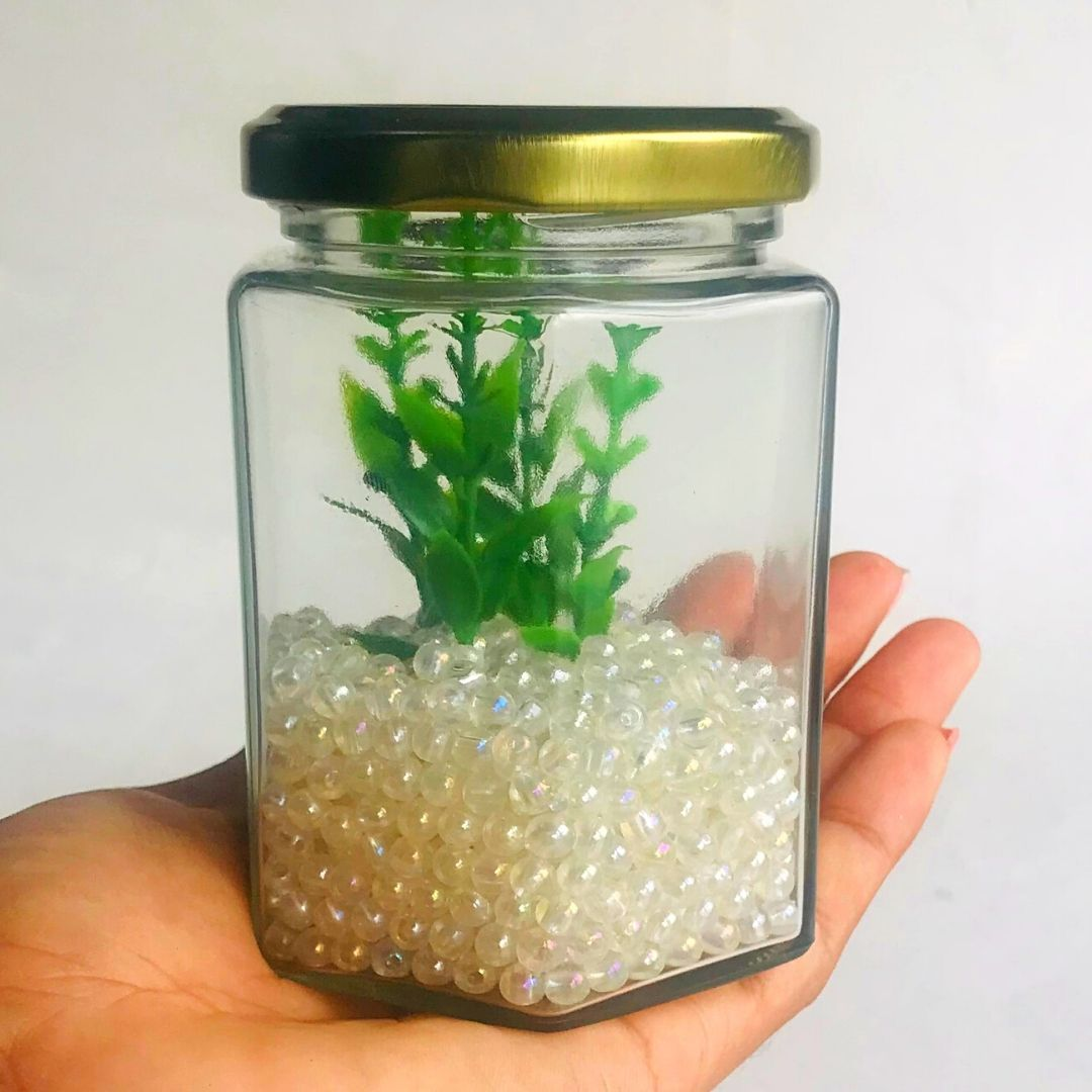 Frasco de vidrio hexagonal con tapa dorado